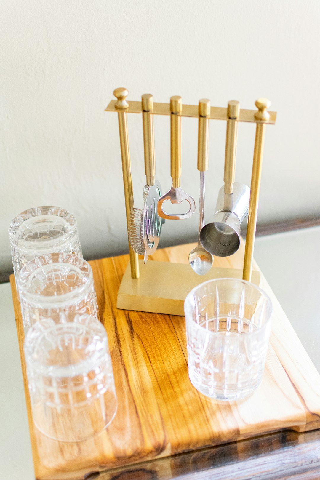 A clear glass of water with lemon slices, next to a full, reusable water bottle on a desk or counter.
