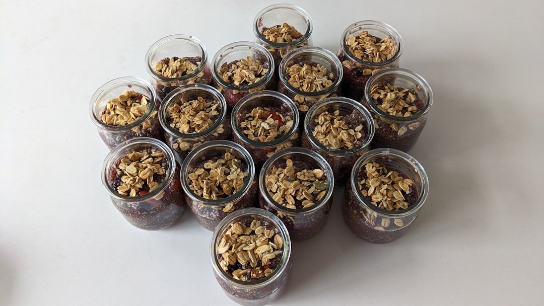 A small jar of overnight oats topped with banana slices and a few chia seeds.